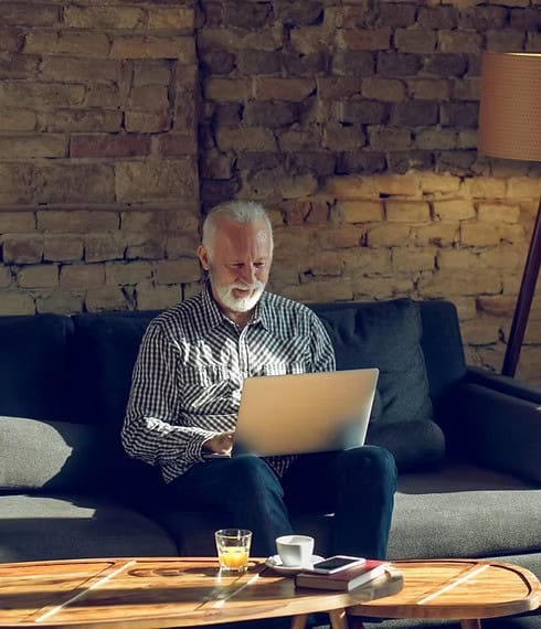 Older man using a laptop in a living room