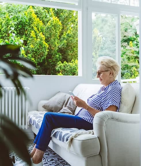 Woman using a tablet by a window