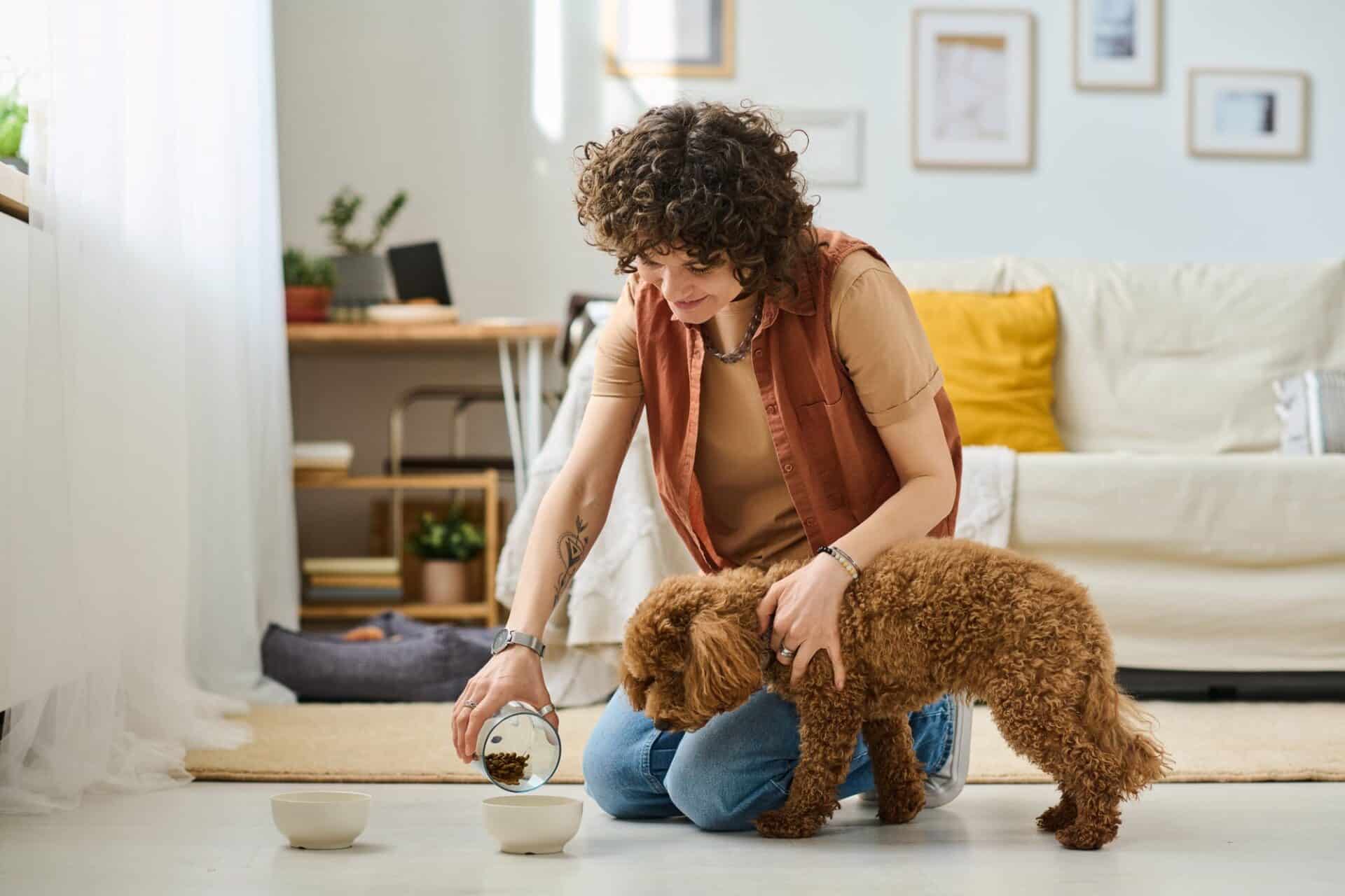 Woman feeding a dog at home