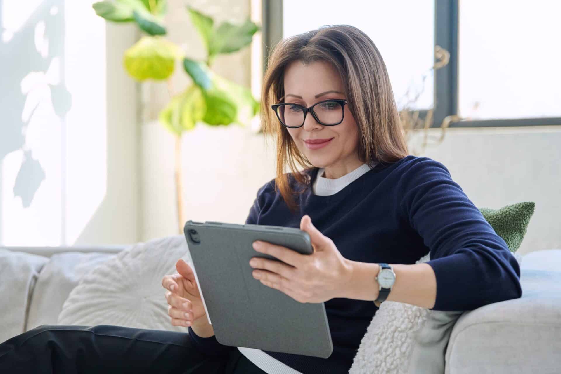 Woman using a tablet on a sofa